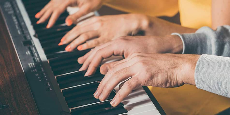 Hands of man playing upright piano