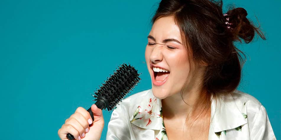 Close-up van een vrouw die zingt met een haarborstel